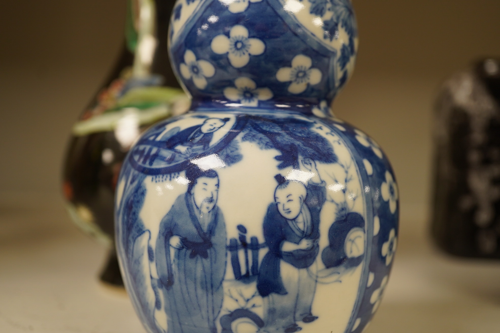 Two Chinese vases; a blue and white double gourd vase and famille noir vase, famille noir 19cm high. Condition - good